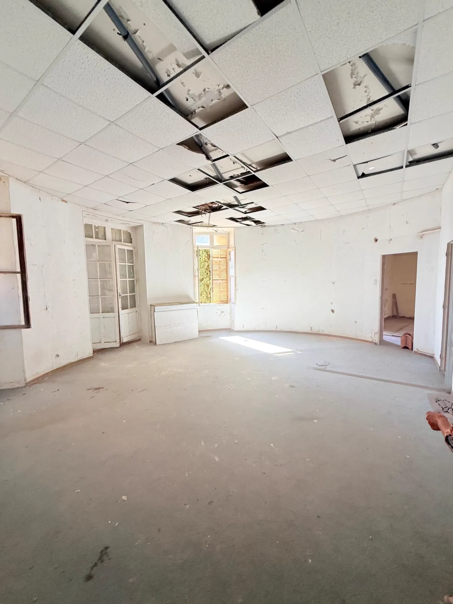 Enfilade du lot 1.04 avant travaux, porte vers la chambre et menuiseries d'origine