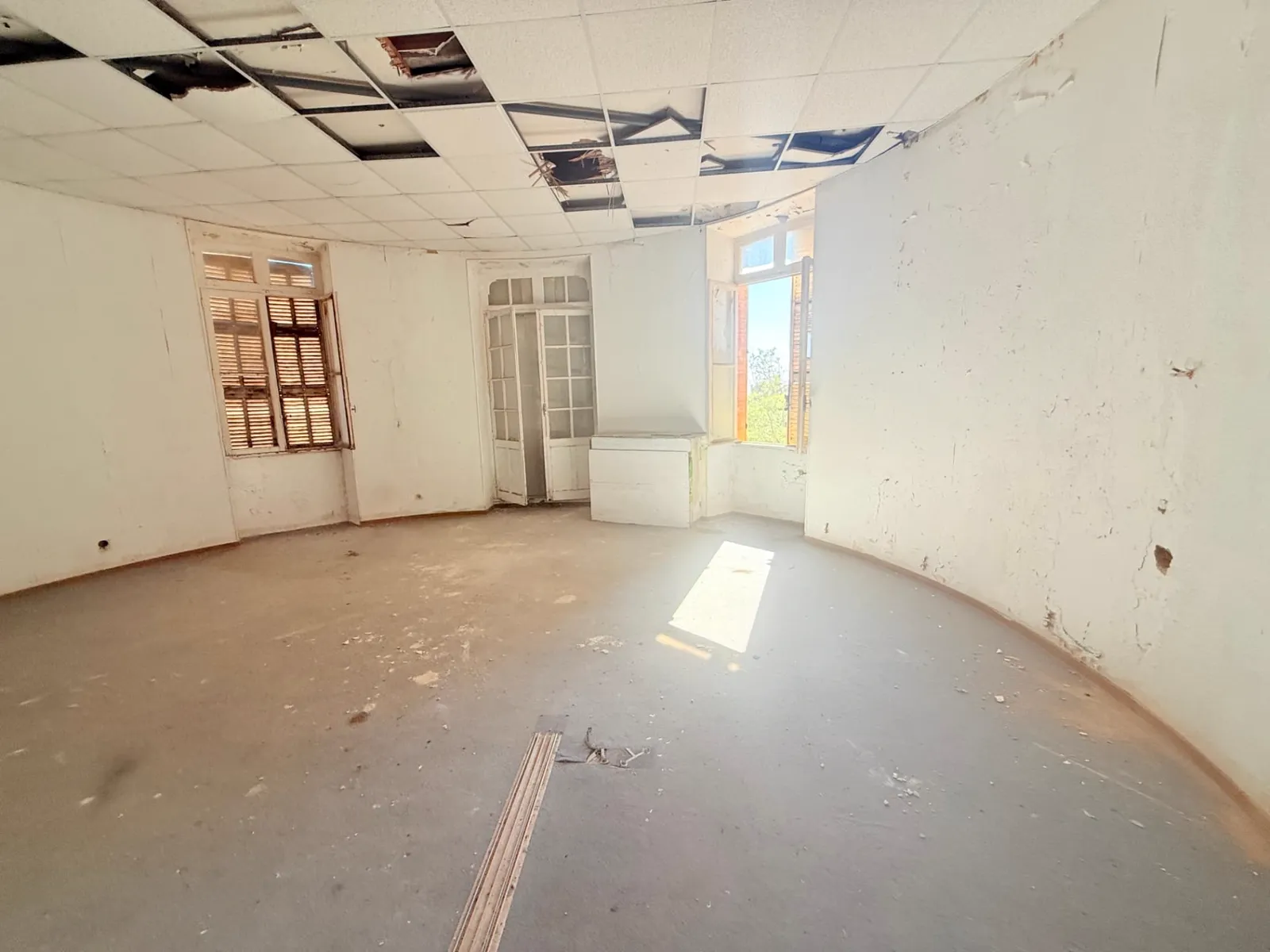 Séjour en rotonde du lot 1.04 du château des Bormettes avant restauration, fenêtres à persiennes d'origine